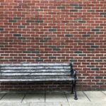 Grey Wooden bench beside brown wall By Elisabeth Lee from Unsplash